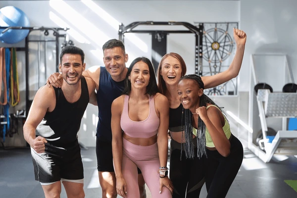 Happy group of friends posing together in a gym