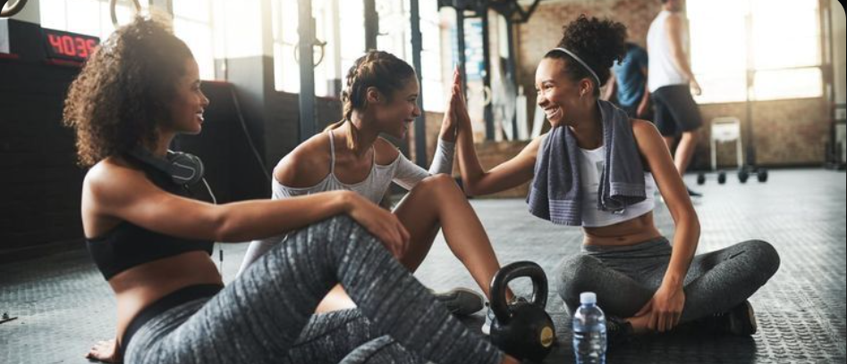 Group fitness class doing lunges with medicine balls